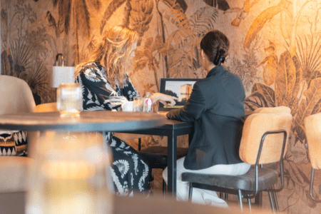 Twee personen werken in de lounge op de 2e etage van Van der Valk Hotel Houten aan een hoge tafel