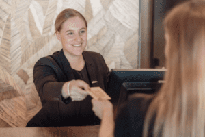 Gast ontvangt kamersleutel bij receptie van Van der Valk Hotel Houten